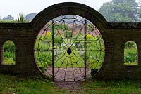 Le jardin des araignées de Hoveton Hall est ainsi nommé d'après la porte circulaire dans la conception d'une toile d'araignée.