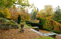 Une vue depuis une terrasse sur en forme de nuage Taxus baccata, Buxus, et Fagus sylvatica Feuillage d'automne à haute au jardin des Arts et Métiers à High Moss, Portinscale, Cumbria, Royaume-Uni