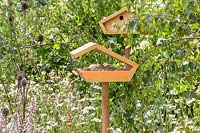 Mangeoire à oiseaux en bois et nichoir sur poteaux en bois dans le jardin de la faune. Springwatch Garden, Exposition florale de Hampton Court, 2019.