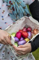 Enfant ramassant des oeufs de Pâques colorés de fort haie
