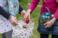 Enfants collectant des œufs en chocolat colorés dans des paniers à Pâques