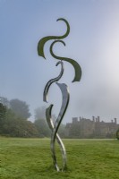 Sculpture contemporaine en métal cinétique sur une pelouse de jardin en été - juillet