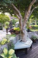 Terrasse en bois de planches de la jetée de Southport avec enseigne de moulin récupéré et Acer entouré d'un siège donnant sur le jardin