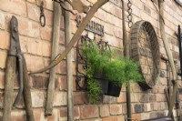Affichage de vieux outils et équipements de jardinage sur mur de briques