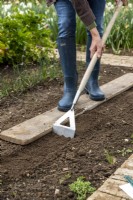 Utiliser une houe pour préparer le sol pour semer des graines