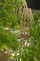 Structures en treillis de bambou laminé dans une piscine entourée de plantes aquatiques dont Nymphaea et Pontederia cordata le Guangzhou Chine : Guangzhou Garden, lauréat du meilleur jardin d'exposition.