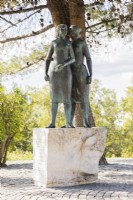 Sculpture de deux femmes sur socle dans le parc.