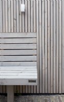 Banc en bois spécialement conçu à la clôture en bois. Éclairage à la clôture.