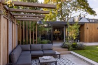 Pergola et patio dans jardin contemporain avec vue vers salon de jardin ou bureau