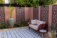 Patio de style marocain dans le jardin de banlieue avec des écrans décoratifs sur le mur