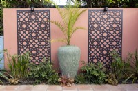 Phoenix Palm contre un mur aux couleurs vives avec des écrans décoratifs
