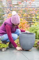 Femme plaçant des pierres sous le pot pour aider au drainage