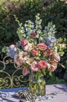 Grand bouquet de fleurs bleues et abricot en pot de verre sur table - Delphiniums ; Eustoma lisianthus et roses