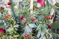 Cône de pin et boules dans un pot de Noël à feuilles persistantes