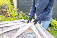Femme utilisant des boulons et des rondelles pour commencer à assembler les planches de bois en forme d'étoile