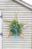 Étoile décorative accrochée à un mur en bois vert pâle