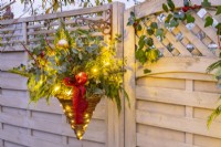 Panier suspendu de Noël à feuilles persistantes illuminé de guirlandes lumineuses