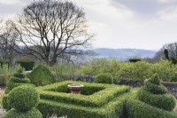 Vue ouest à travers le jardin formel à Perrycroft, Herefordshire en mars avec fort découpé autour d'un bain d'oiseaux central.