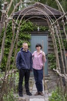 Vue à travers l'arche rustique pour couple standing in garden