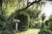 Sculpture de Peter M Clarke montée sur un socle en bois avec deux sièges à Balmoral Cottage, Kent en avril