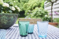 verres bleus sur la nappe avec vue sur le jardin