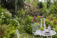 Coin salon au parterre d'hortensias avec hortensias de jardin, lys à crête, Hydrangea quercifolia 'Snowflake'.