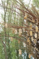 Arche de branches de saule remplie d'assiettes à souhaits en bois réalisées par l'artiste de la nature Will Beckers.