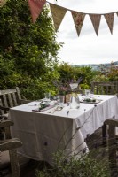 Terrasse avec ensemble table et chaises, guirlande ornée de lavande et autres fleurs - Histoire de fête d'été à la lavande