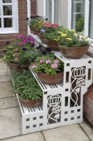 Étagère Art déco pleine de pots colorés au jardin de Hamilton House en mai