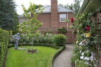 Fil sculpture d'un homme jardinage par Derek Kinzettin le jardin de devant à Hamilton House garden en mai