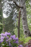 Sculpture en fil de fer d'une fée suspendue dans les arbres, par Derek Kinsett au jardin de Hamilton House en mai