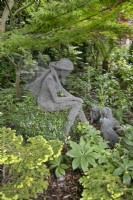 Fil sculpture d'une fée avec trois petits chiens par Derek Kinsett à Hamilton House garden en mai