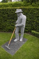 Sculpture en fil d'un homme jardinant par Derek Kinzett dans le jardin de devant à Hamilton House garden en mai