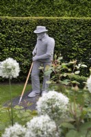 Sculpture en fil d'un homme jardinant par Derek Kinzett dans le jardin de devant à Hamilton House garden en mai