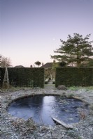 Étang gelé dans un jardin à la française en hiver