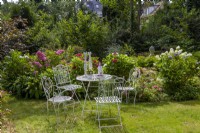 Coin salon au parterre d'hortensias avec hortensias de jardin, lys à crête, Hydrangea quercifolia 'Snowflake'. En arrière-plan Cichorium intybus