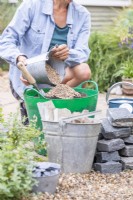 Femme mélangeant du gravier avec du compost