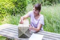 Femme copiant le dessin du papier sur la traverse en bois