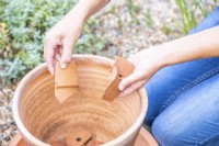 Femme plaçant des pots dans le pot