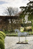 Cheval d'étain décoratif dans un jardin de campagne au printemps