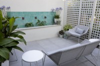 Patio contemporain avec crème solaire blanche, fontaine à eau et sièges de jardin blancs