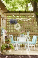 Table et chaises vintage en bleu et blanc sur un patio en treillis