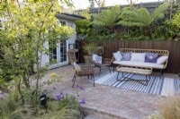 Patio avec mobilier de jardin de banlieue avec bureau de jardin en arrière-plan