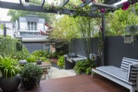 Terrasse en bois composite, pergola et petit jardin dans la cour du centre-ville.