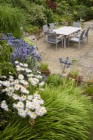 Jardin de la cour avec coin repas entouré de plantes dans le jardin à Cow Close Cottage, North Yorkshire en juillet