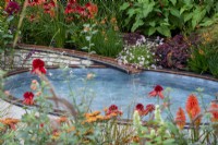 Ruisseau d'eau en cuivre qui coule dans un étang surélevé entouré de plantations colorées - Trouver notre chemin : un jardin d'hommage NHS, RHS Chelsea Flower Show 2021