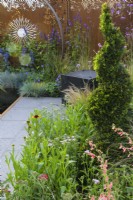 Panneaux en acier Corten entourant la plantation d'un topiaire d'if en spirale avec Penstemon barbatus 'Roseus' et Achillea 'Paprika' - Sunburst Garden, RHS Hampton Court Palace Garden Festival 2022