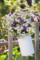 Bouquet blanc violet contenant de la verveine, de l'achillée et des marguerites.
