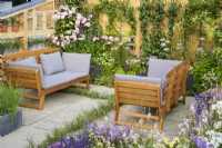 Coin salon entouré de plantations pastel avec des roses roses - Knolling with Daisies, RHS Hampton Court Palace Garden Festival 2022