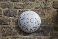 Panneau lumineux de la maison de la pleine lune grange sur le mur de pierre rustique